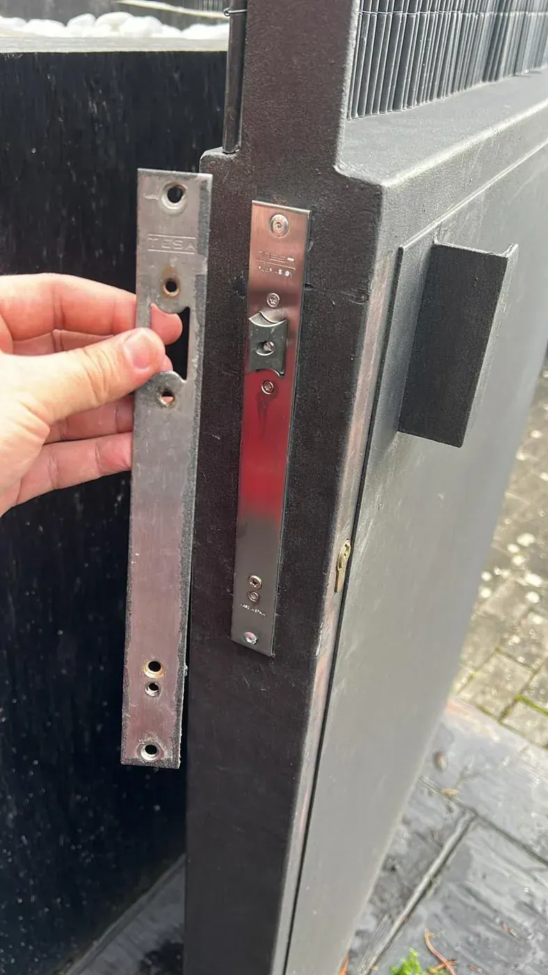 Cerradero nuevo montado en una puerta metálica de portal