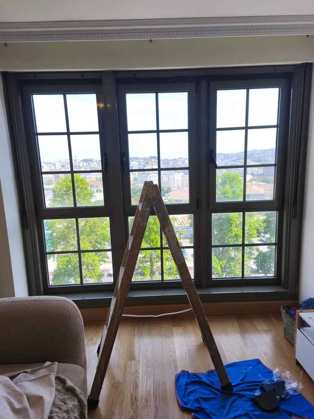 Galería acristalada de un piso de A Coruña con la escalera montada durante el trabajo en las persianas