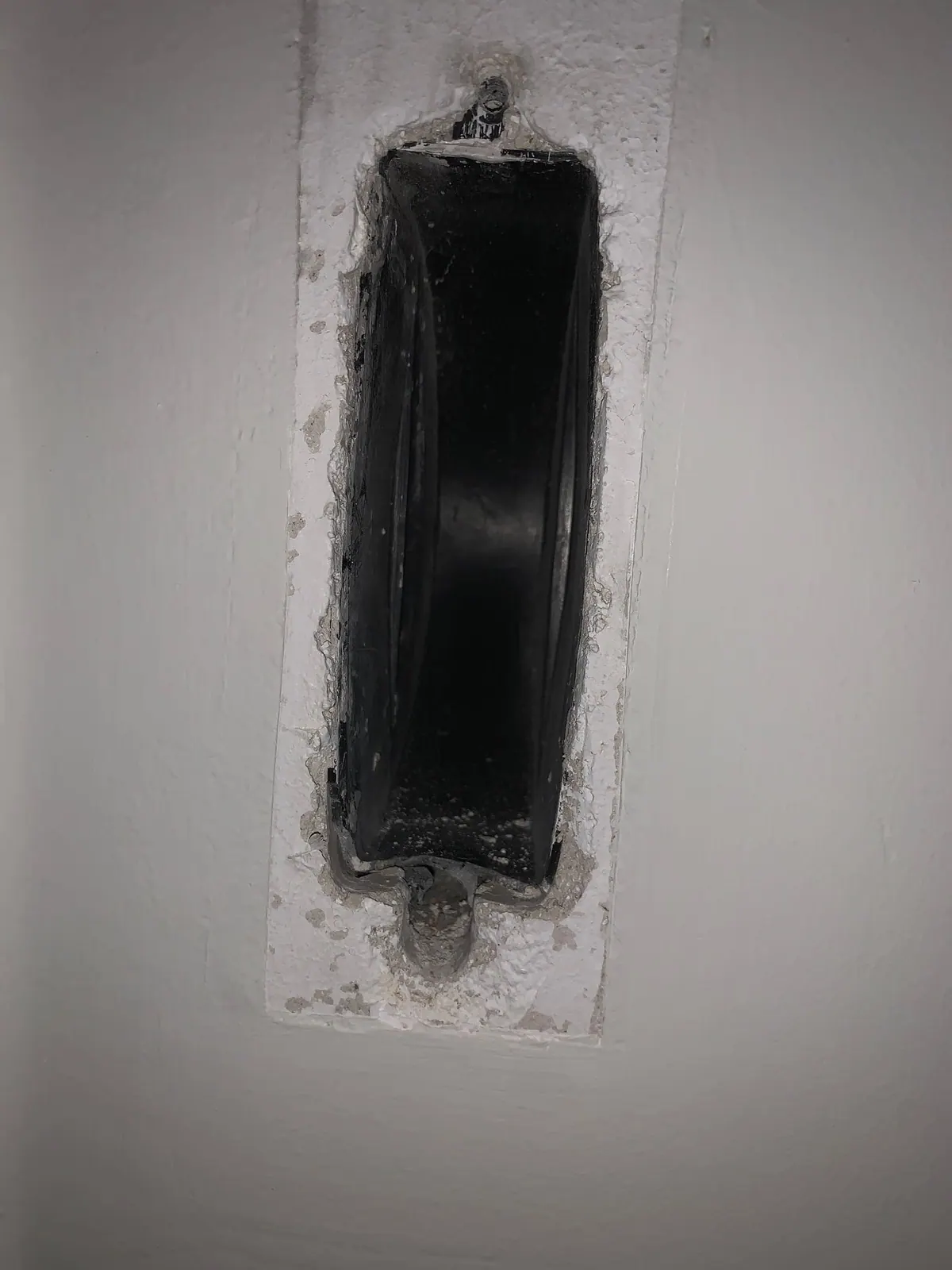 Hueco del recogedor empotrado vacío en la pared, preparado antes de montar el mecanismo nuevo