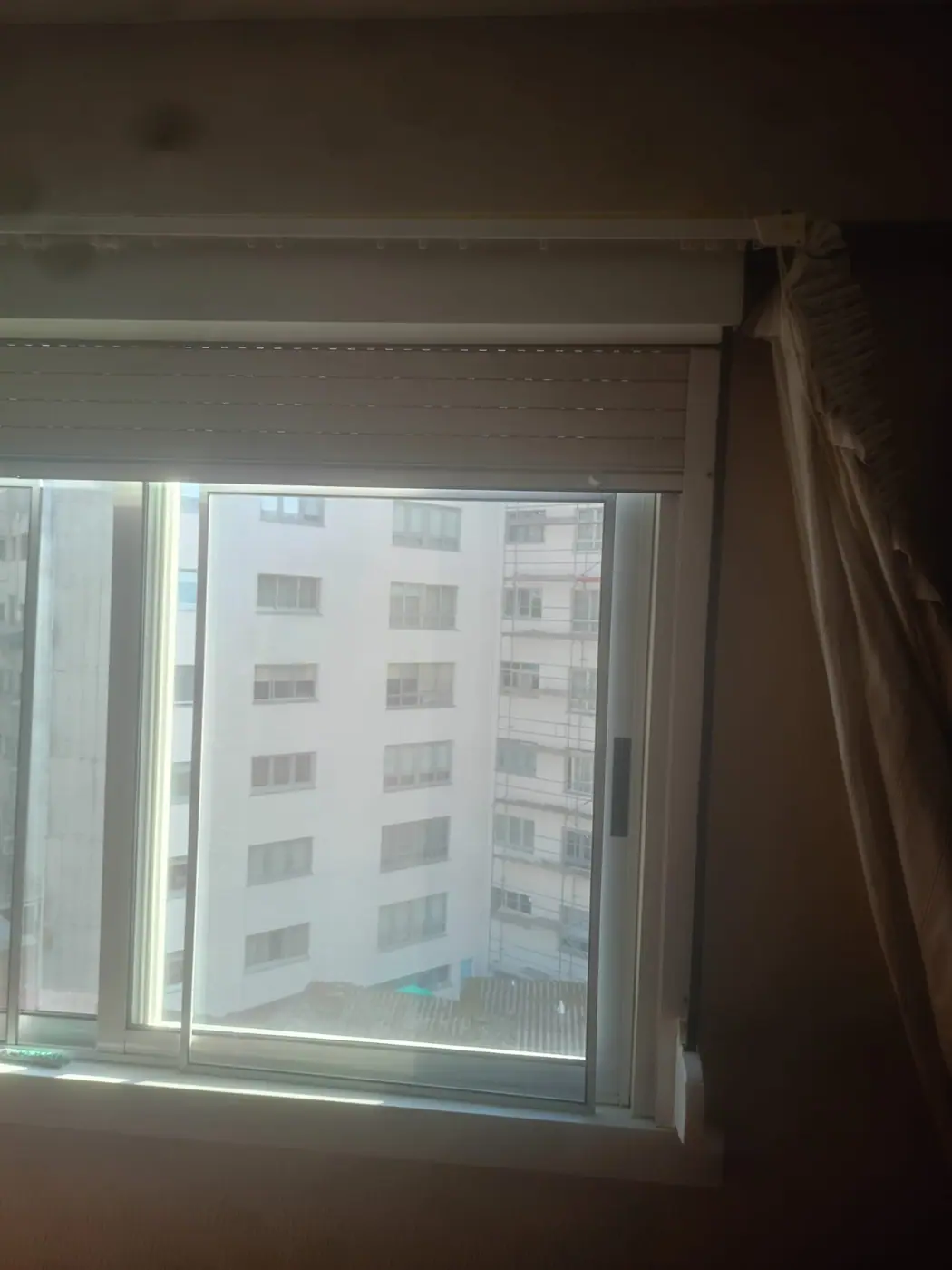 Persiana bajada a media altura en una habitación todavía protegida durante el trabajo
