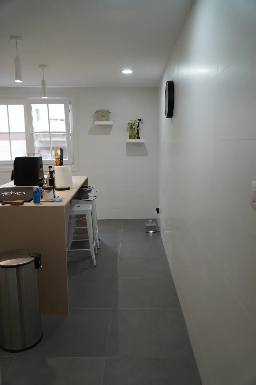 Cocina reformada con isla y suelo porcelánico gris