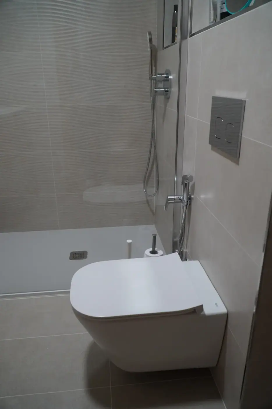 Plato de ducha blanco extraplano con mampara de cristal en baño reformado