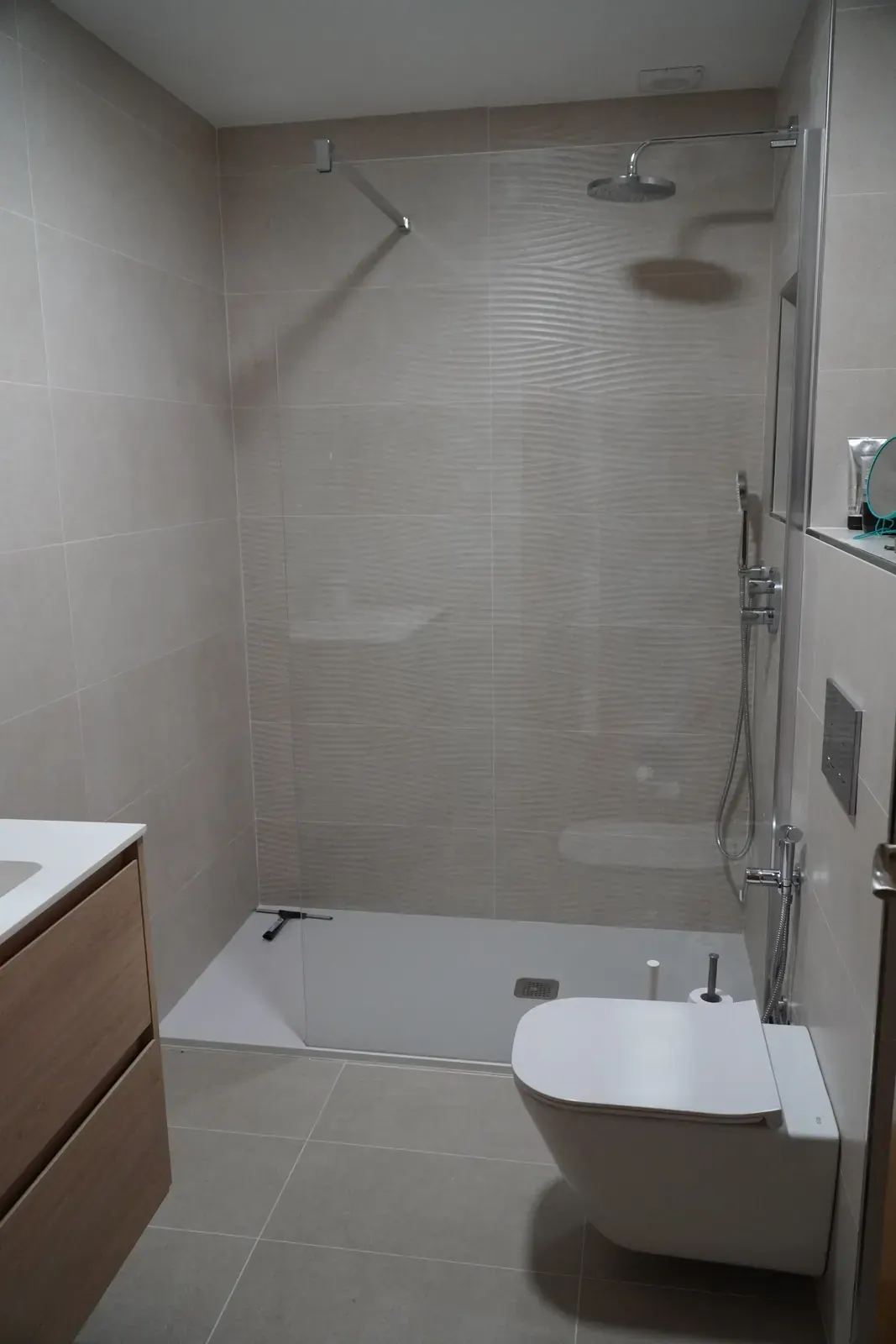 Lavabo y espejo redondo en baño reformado en A Coruña